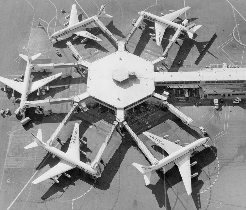 United Airlines DC-8 jets at loading bridges at SFO Airport, c. 1962.