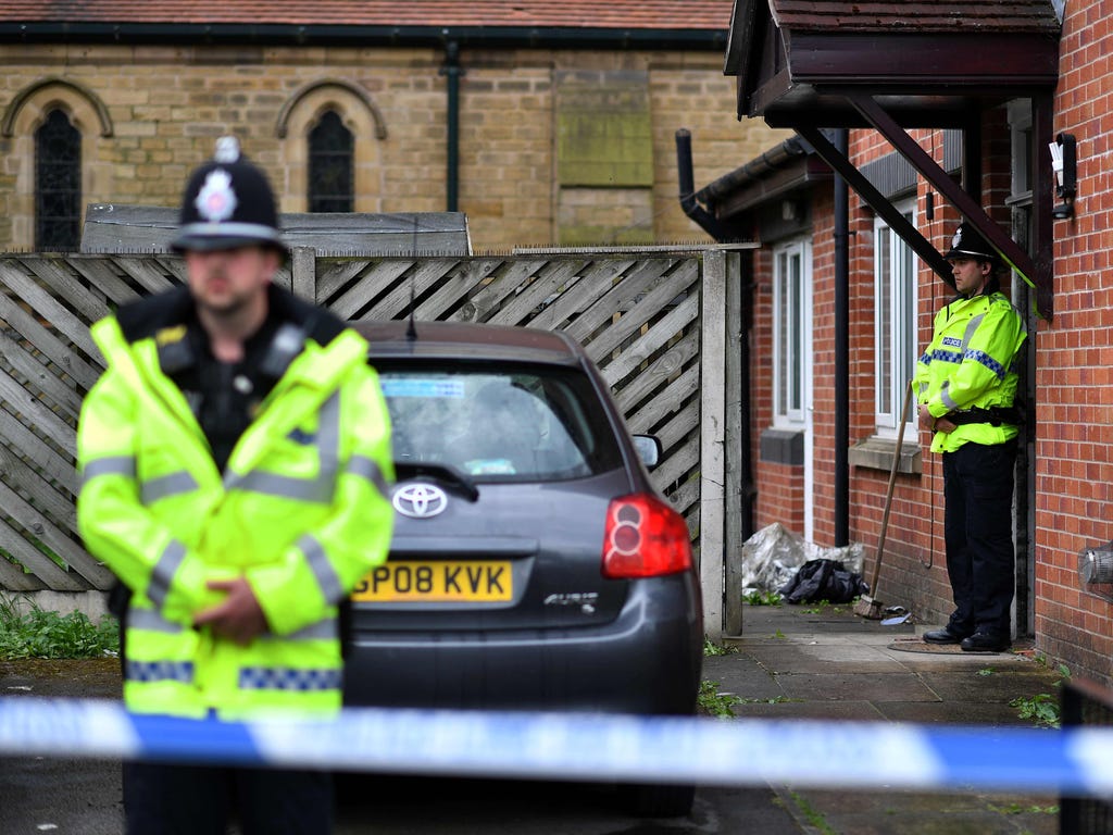 Policemen stand guard at a cordon around a house, which had been raided in a police operation in the early hours of the morning, at Cheetham Hill in Manchester on May 27, 2017.\u000dBritish police said they arrested two more people during raids Satur