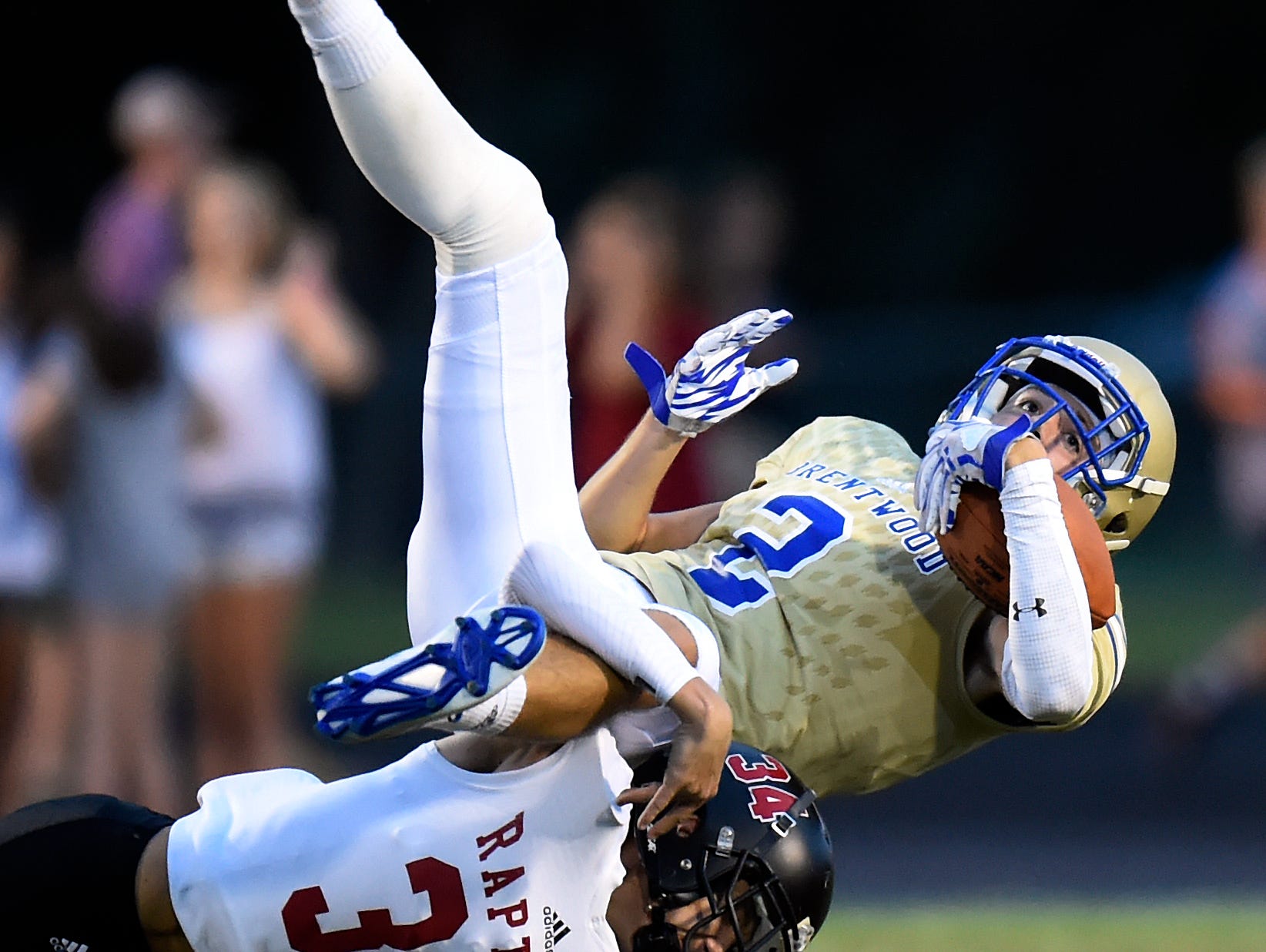 Brentwood wide receiver Parker Bullion (2) is upended by Ravenwood cornerback Elijah Dryer (34) after Bullion caught a pass during the first of an high school football game on Friday, Aug. 26, 2016, in Brentwood, Tenn.