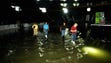 Workers and contractors survey the rising floodwaters