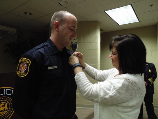 Cindy Renner pins a badge on her son Patrick's chest.