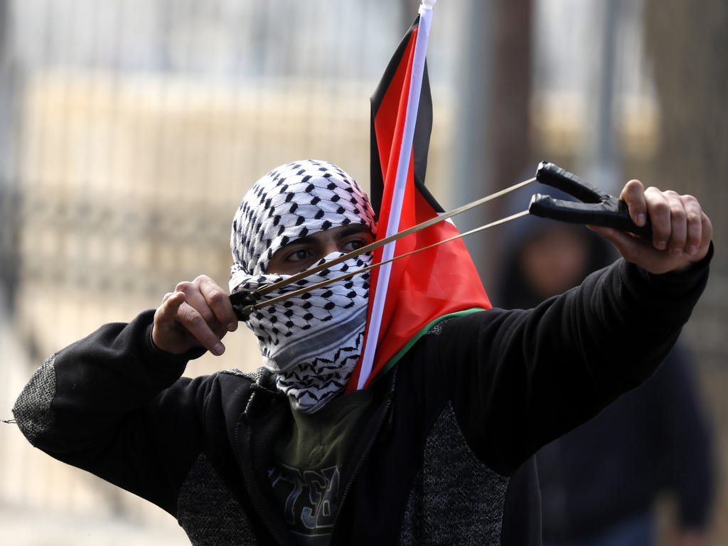 A Palestinian uses a sling shot to hurl stones against Israeli troops during a demonstration against President Trump's recognition of Jerusalem as Israel's capital, in the West Bank city of Bethlehem on Dec. 27, 2017.