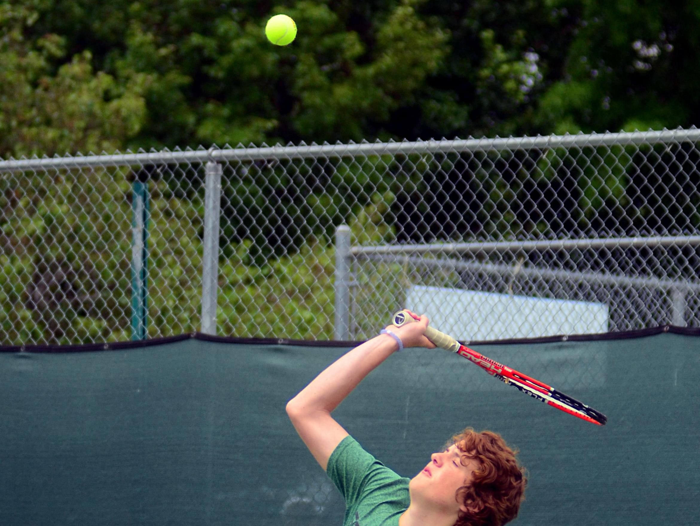 Gallatin High junior Justin White hits a serve during his first-round singles match on Tuesday at the District 9-AAA Individual Tennis Tournament.