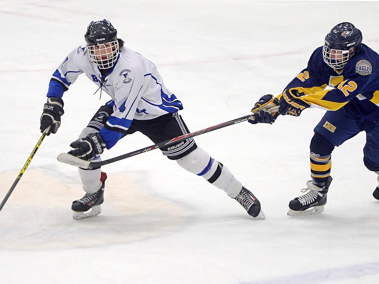 Brockport's Mitchell Henshaw, left, skates the puck away from Irondequoit's Michael Coholan.