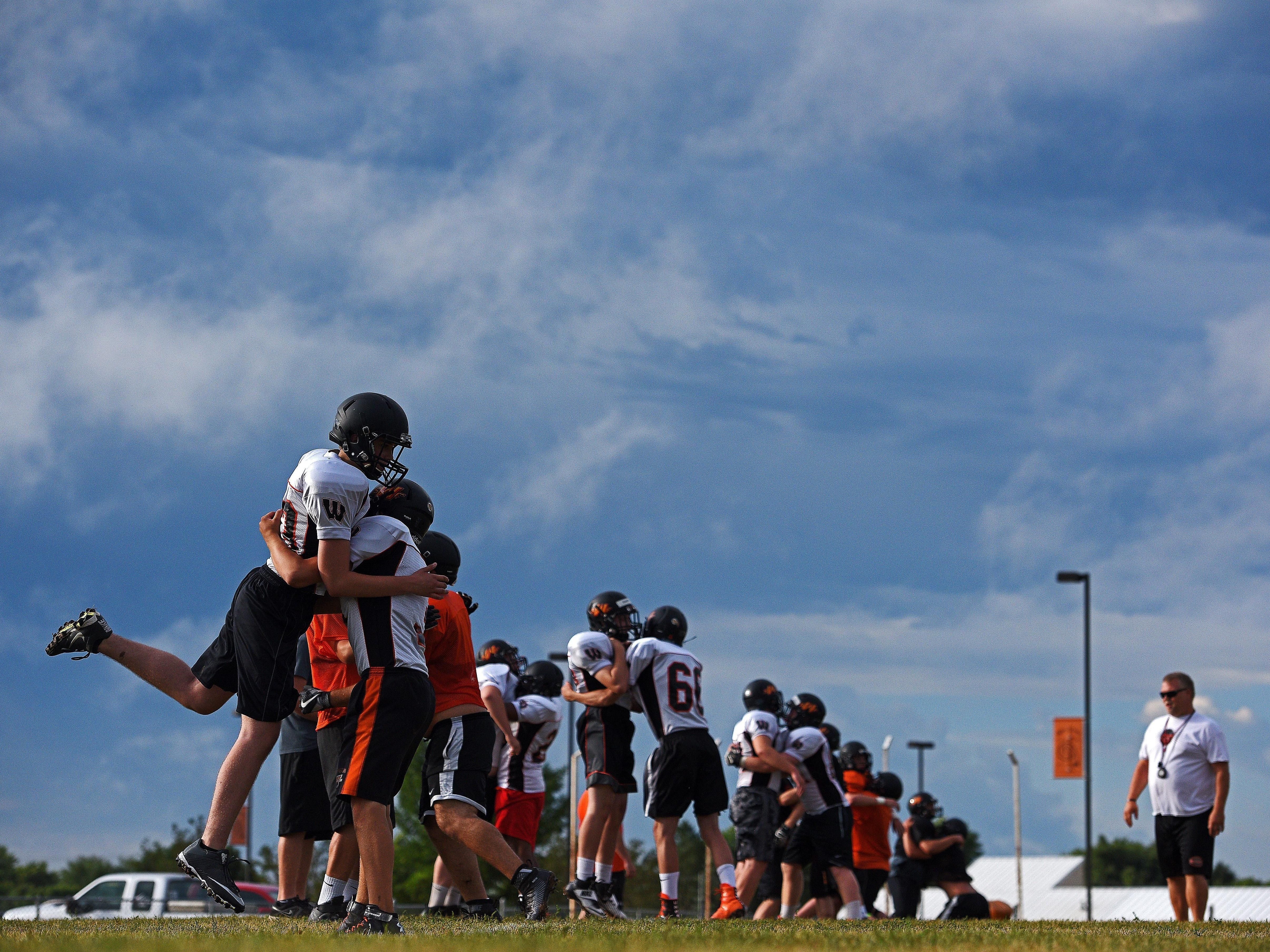 Washington High School football players, including Cody Jennings (83), far left, and Dillon Gard (3), second from left, take part in a drill during a Washington High School Football Practice Thursday, Aug. 11, 2016, at Washington High School in Sioux Falls.