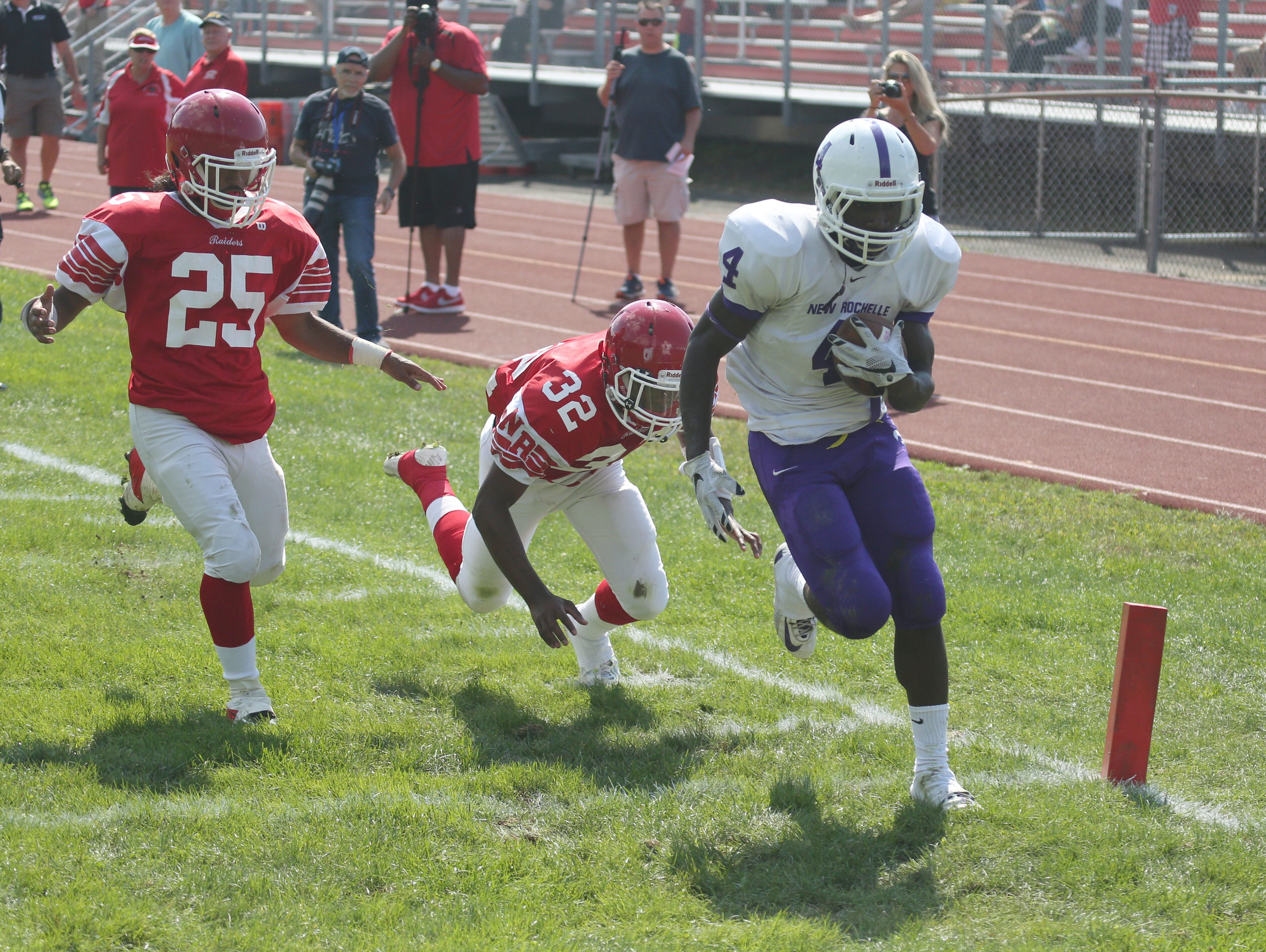New Rochelle's Keelan Thomas scores a first half touchdown as North Rockland's Michael Cintron and Cameron Lewis follow, during action in their game at North Rockland High School, Sept. 19, 2015.