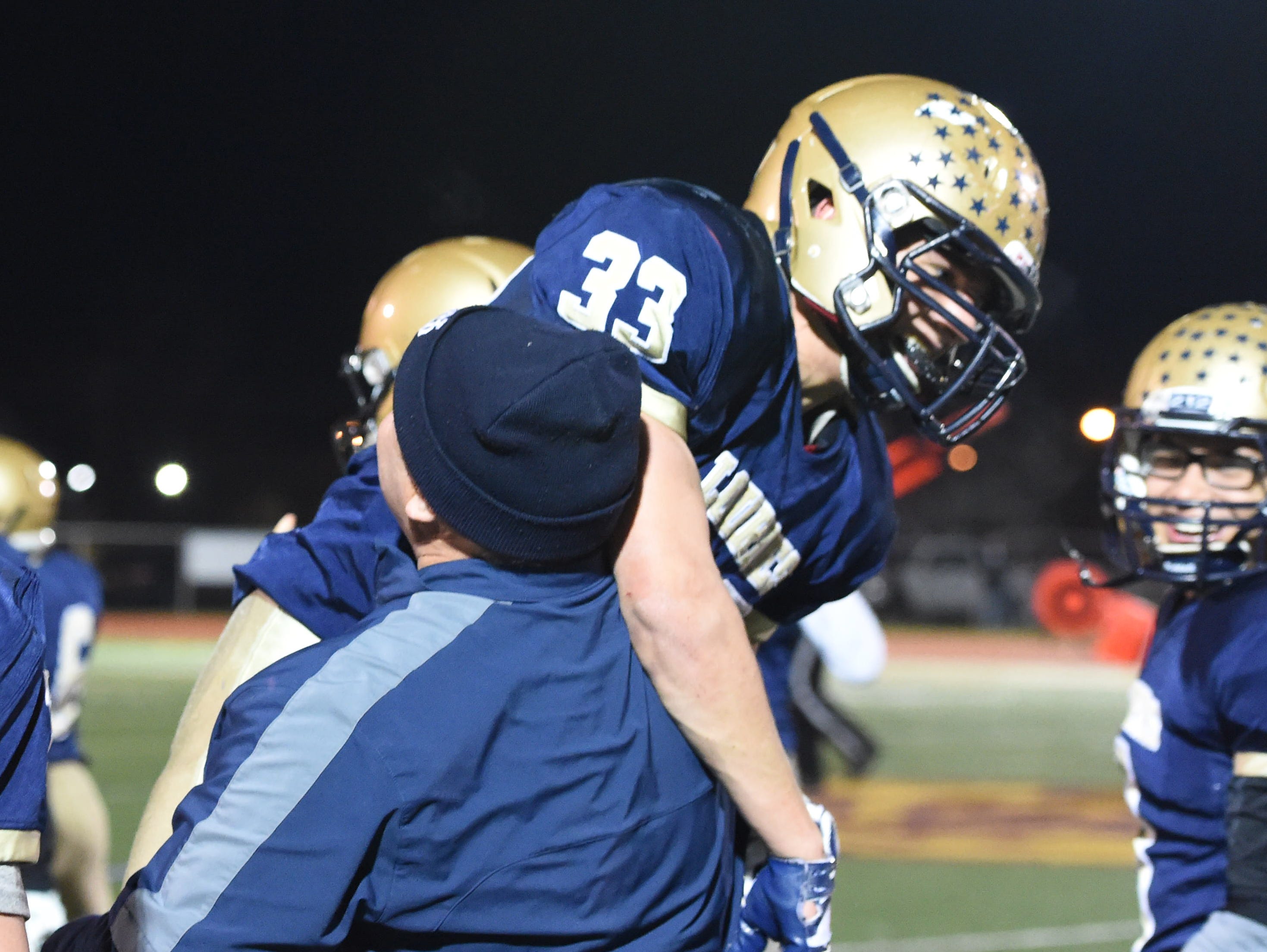 Our Lady of Lourdes High School's Joe Scaglione is hoisted up by a coach on Nov. 20 during a state playoff game at Kingston's Dietz Stadium.