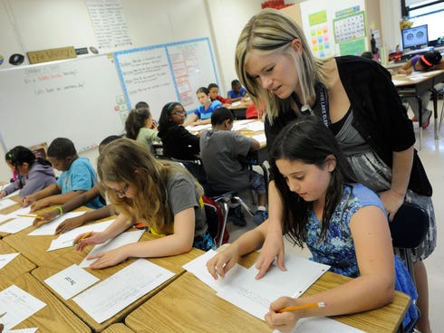 Amy Lawson, a fifth-grade teacher at Silver Lake Elementary in Middletown, Del., helps student Melody Fritz with an English language arts lesson Oct. 1, 2013. The percentage of respondents in a Harris Poll who agreed with the statement 
