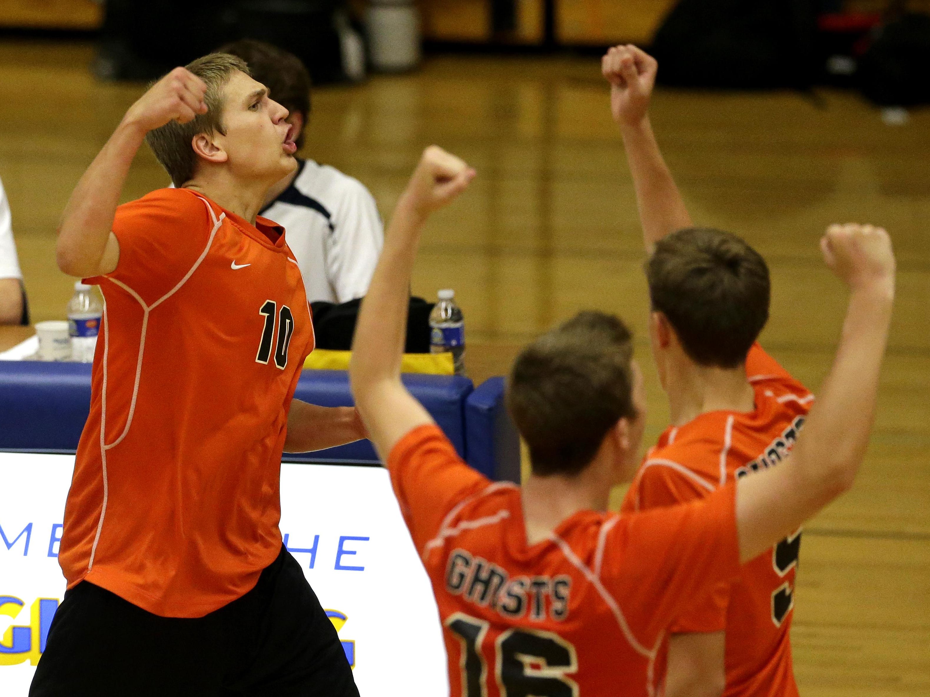 Kaukauna’s Zach Schmidt (left) celebrates with teammates after the Ghosts beat Appleton North in five sets Tuesday at North.