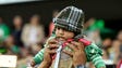 A fan hoists a baby up for a better look at the Mexico-New