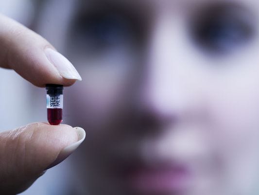 Elizabeth Holmes, CEO of Theranos, holds one of the company's small nanotainers, which contain solitary drops of blood.
