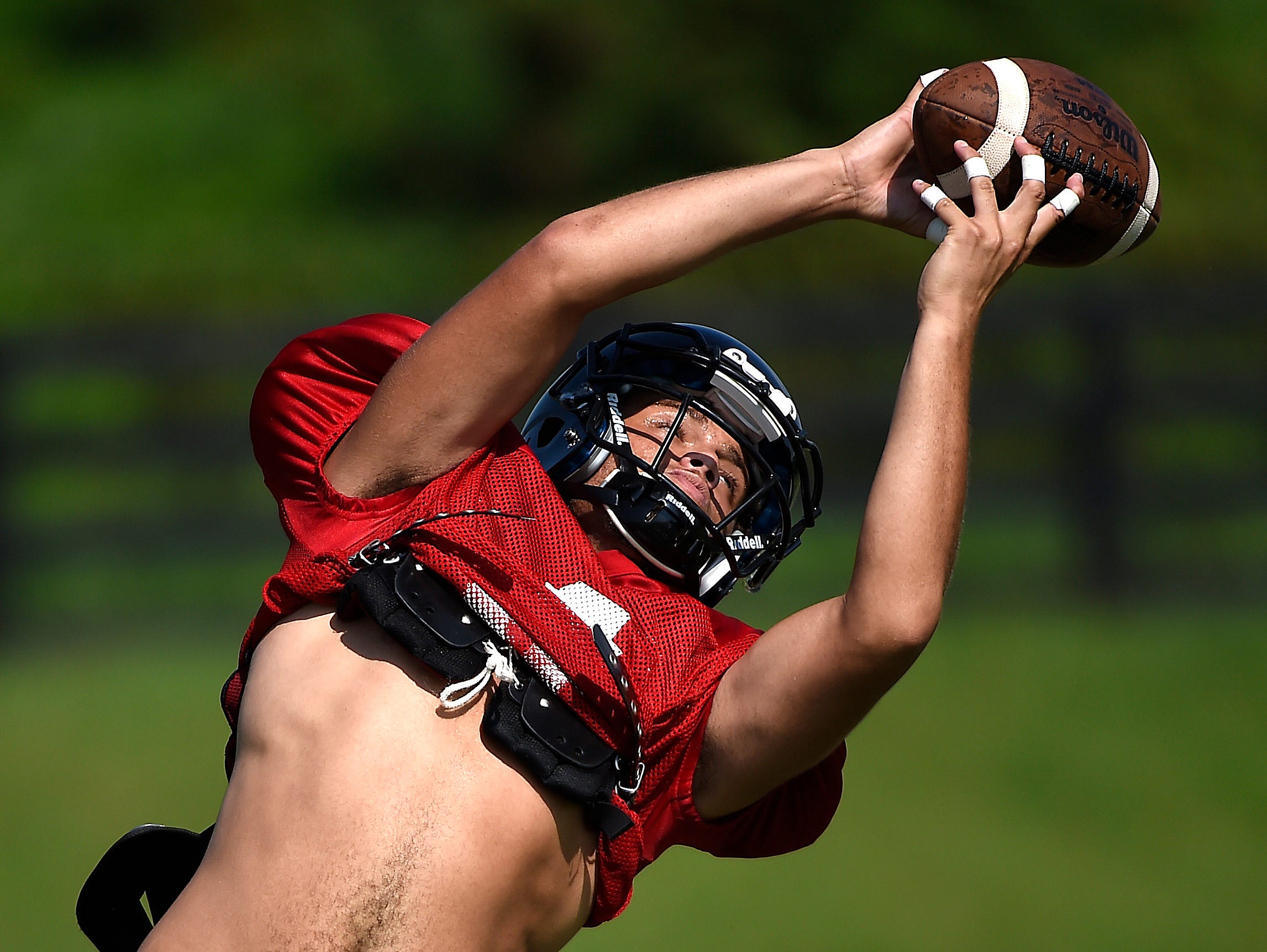 Ravenwood's D'angelow Rice stretches for a pass during passing drills on Monday, the first day of practice in pads for Tennessee high school football teams.