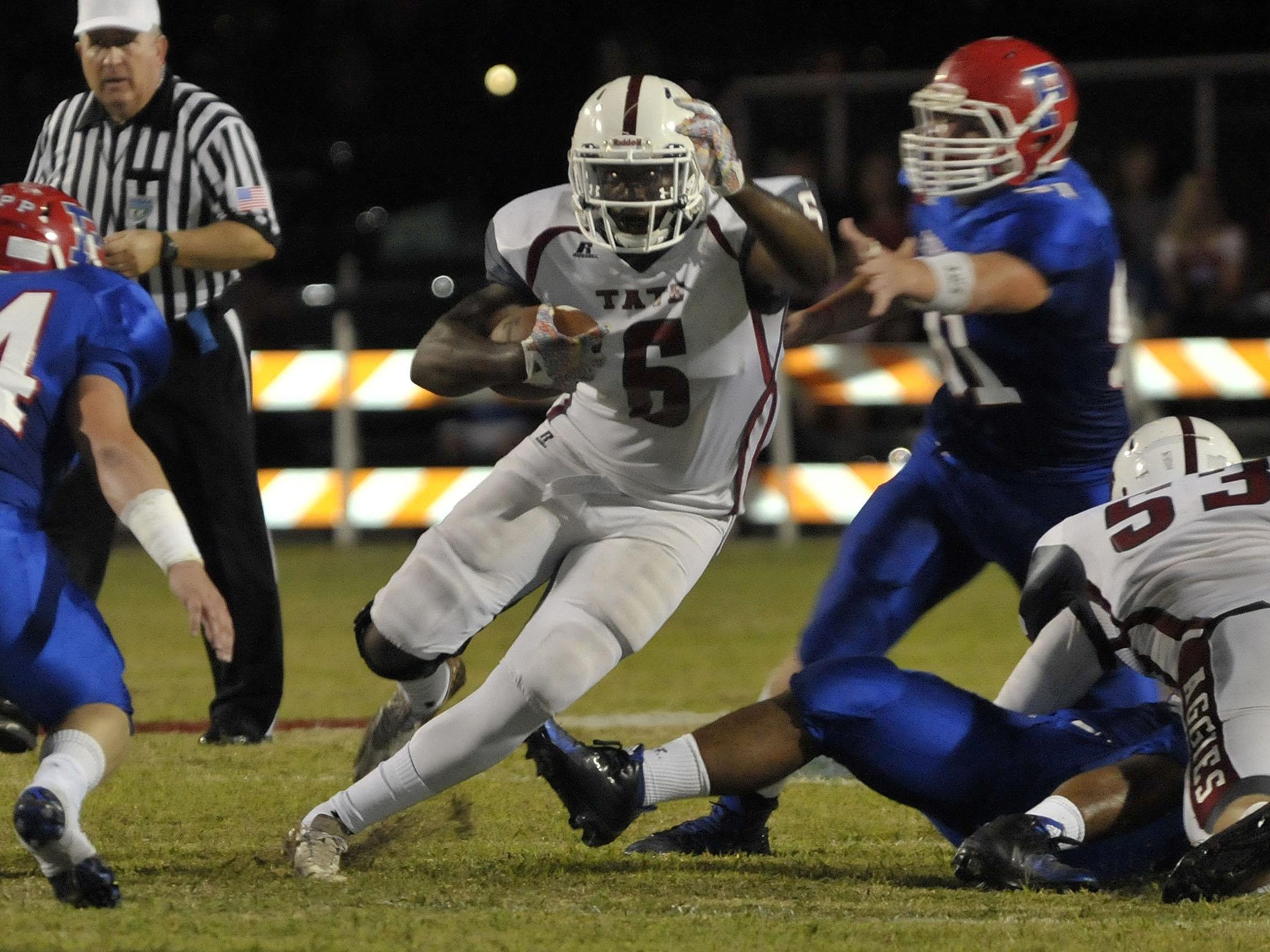 Dee Thompson, No. 6 of the Tate Aggies, weaves his way through the Pace Patriots defense on in early game action between the two teams Friday night at Pace. tate went on to win 48-28.