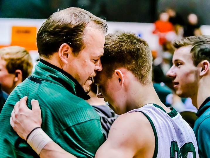 Riley Lewis ,right, of Williamson hugs his father temporary Williamston Head Coach Tom Lewis after their Class B state quarterfinal win over River Rouge Tuesday at Charlotte High School.