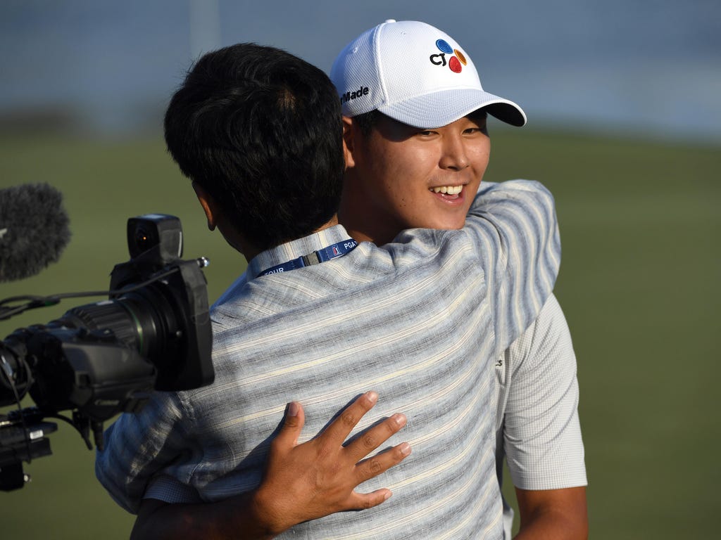 Si Woo Kim gets a congratulatory hug after winning The Players Championship golf tournament at TPC Sawgrass - Stadium Course in Ponte Vedra Beach, Fla.
