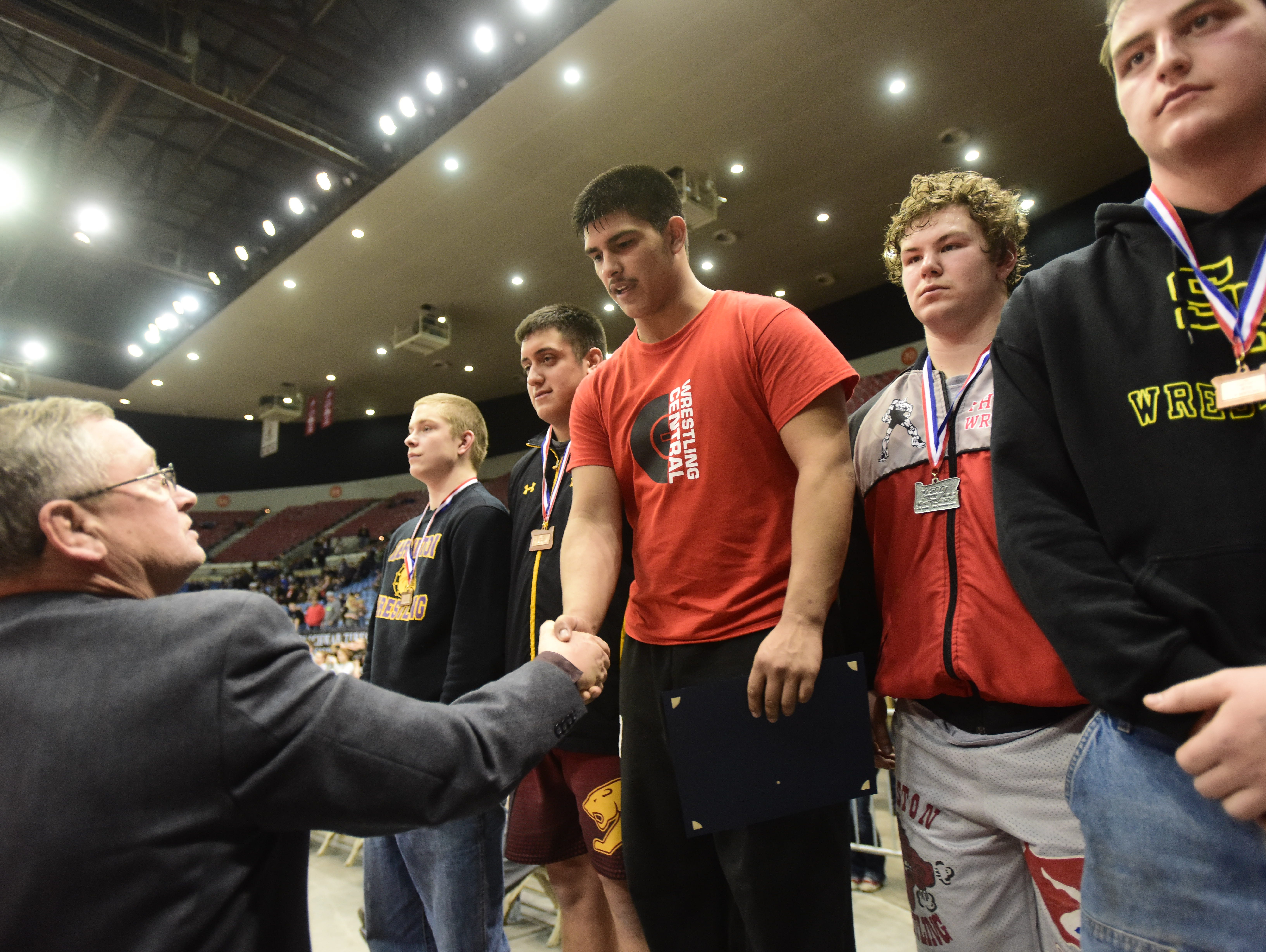 Central senior David Negrete accepts his first-place award at the OSAA State Wrestling Championships at the Veterans Memorial Coliseum in Portland, Ore., on February 25, 2017. (Photo by: Alex Milan Tracy)