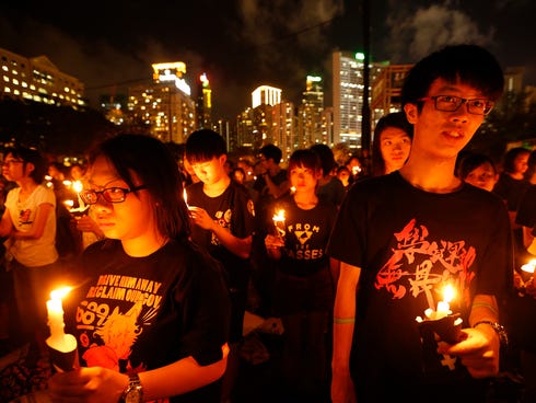 Young participants hold candles as they join tens of thousands of people attending a candlelight vigil at Victoria Park in Hong Kong on June 4, 2014, to mark the 25th anniversary of the June 4 Chinese military crackdown on the pro-democracy movement 
