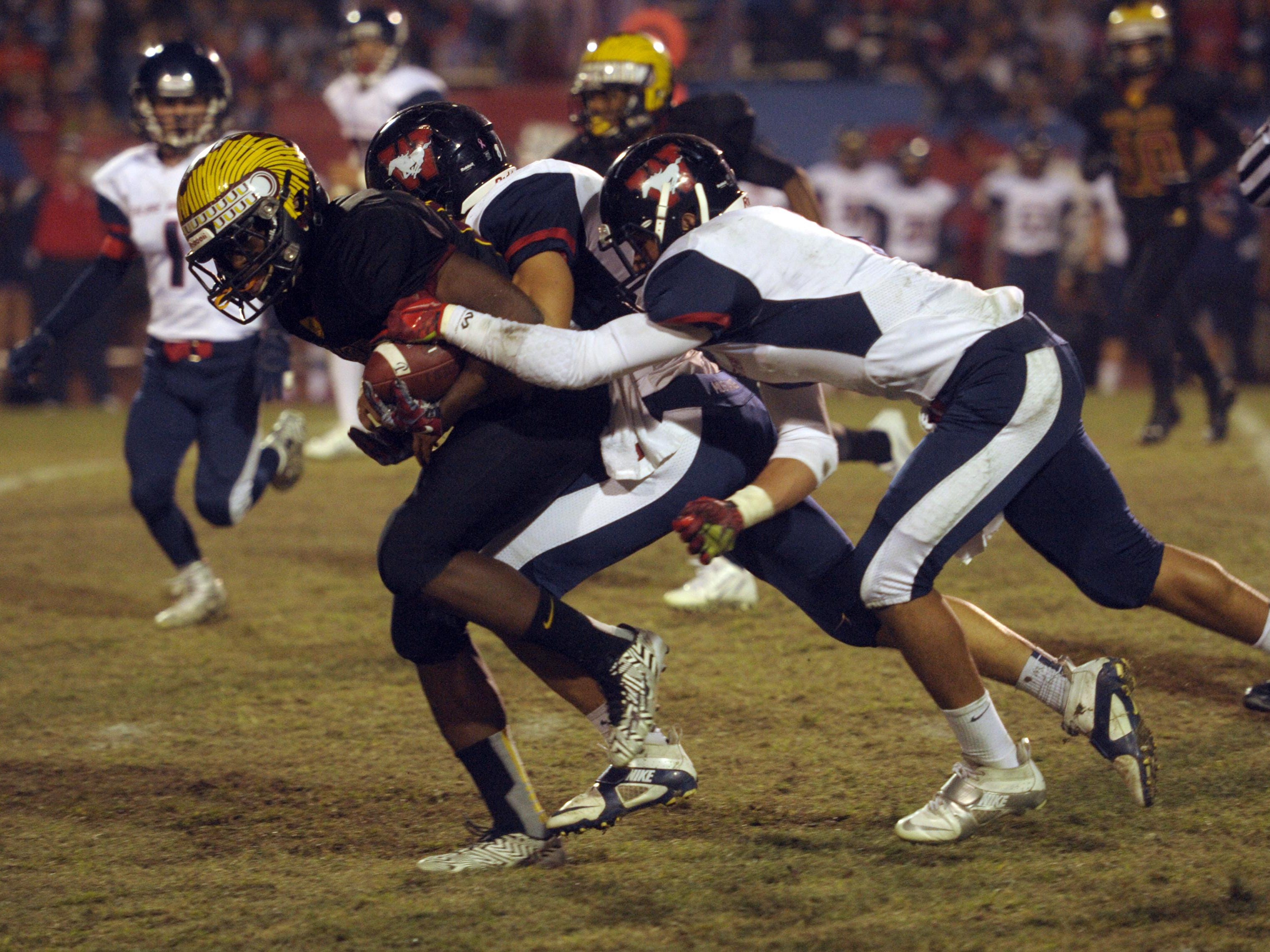 Tulare Union running back Romello Harris (6) tries to carry a couple of Tulare Western defenders during last year’s Bell Game. Tonight’s Bell Game will determine the outright EYL championship.