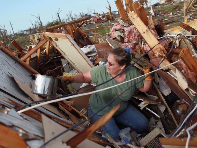 JOPLIN, MO - MAY 24: Dina Meek salvages what she can from her sister-in-law's home after it was destroyed when massive tornado passed through the town killing at least 116 people on May 24, 2011 in Joplin, Missouri. Authorities were prepared to find more bodies in the town of 50,000 people. (Photo by Joe Raedle/Getty Images)