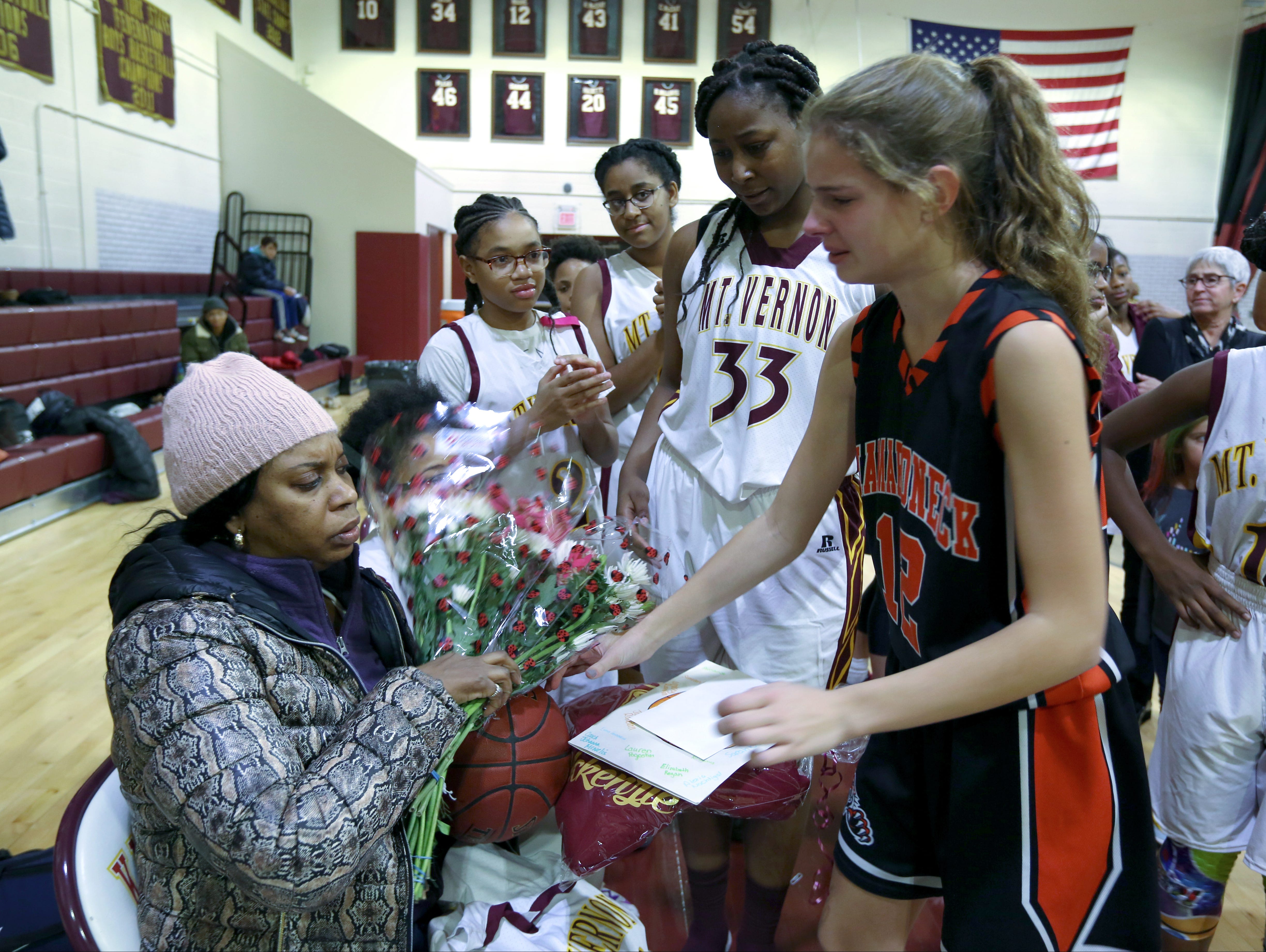 Nadine McKenzie receives flowers before the Mamaroneck at Mount Vernon junior varsity basketball game at Mount Vernon Jan. 6, 2017. Her daughter, Shamoya McKenzie, 13, a member of the Mount Vernon team, was killed by a stray bullet on New Year's Eve.