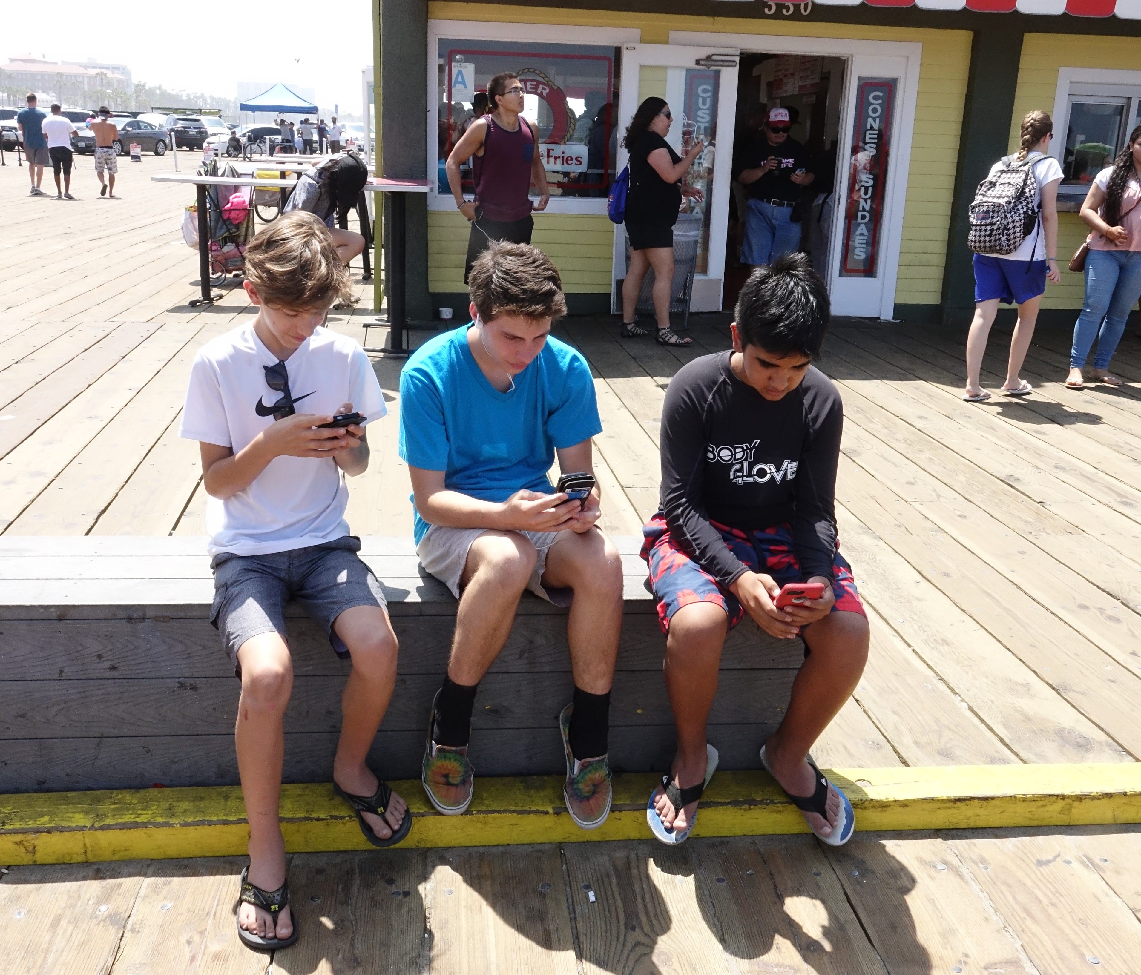 Brothers Lance and Max Santana and Ryan Reinoso play Pokemon Go at the Santa Monica Pier.