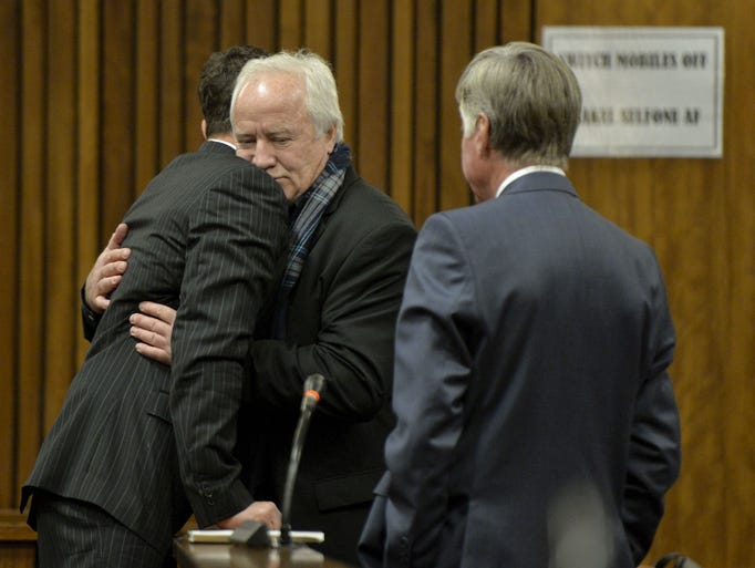 Oscar Pistorius gets a hug from his dad in the Pretoria High Court on Aug. 8, 2014.