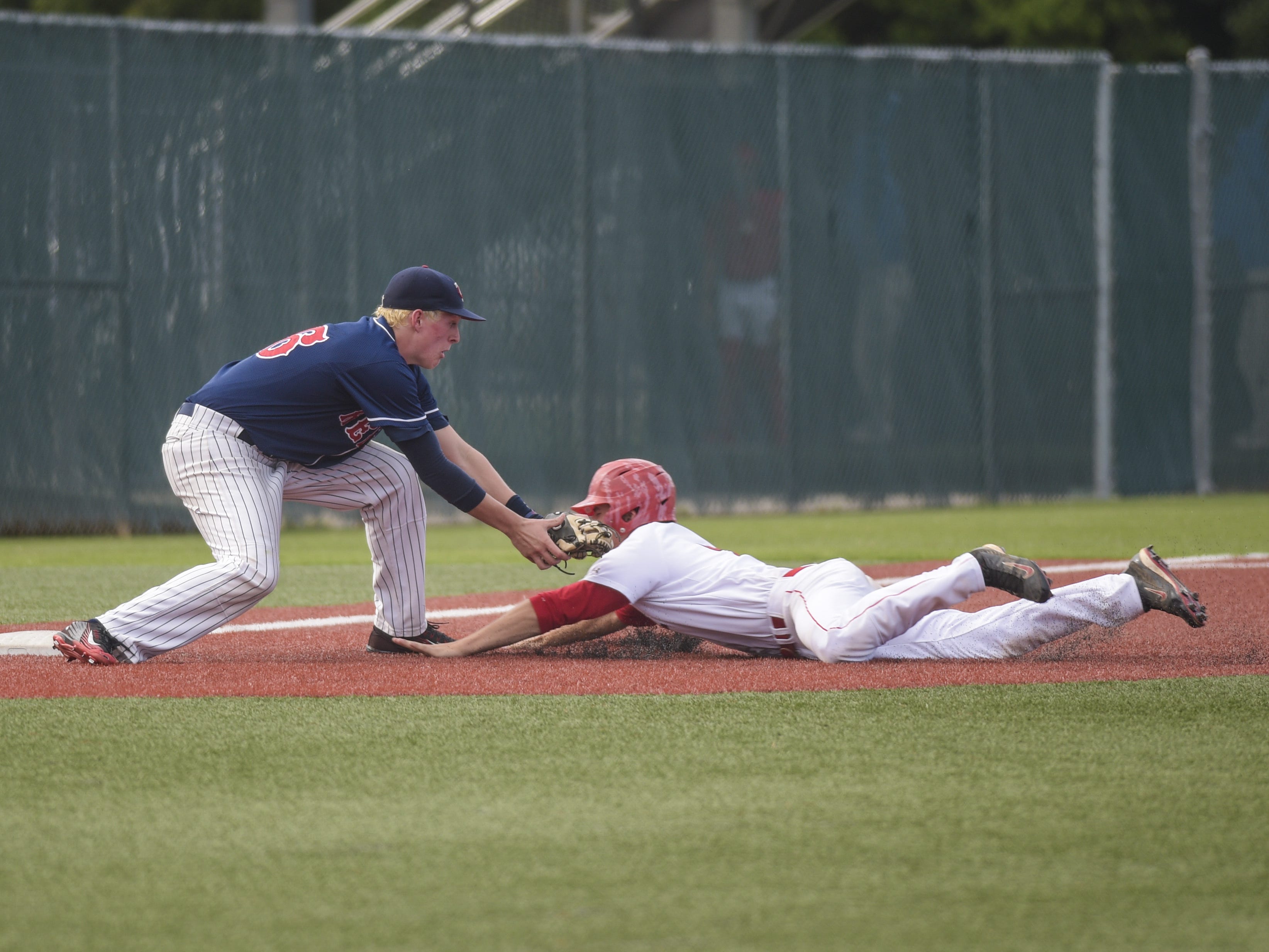 Tioga outfielder Cameron Sanders (7) is tagged out on a slide at third base by Teurlings' third baseman Jonathan Fontenot (26) during the third inning of Thursday's 4A semifinal game.