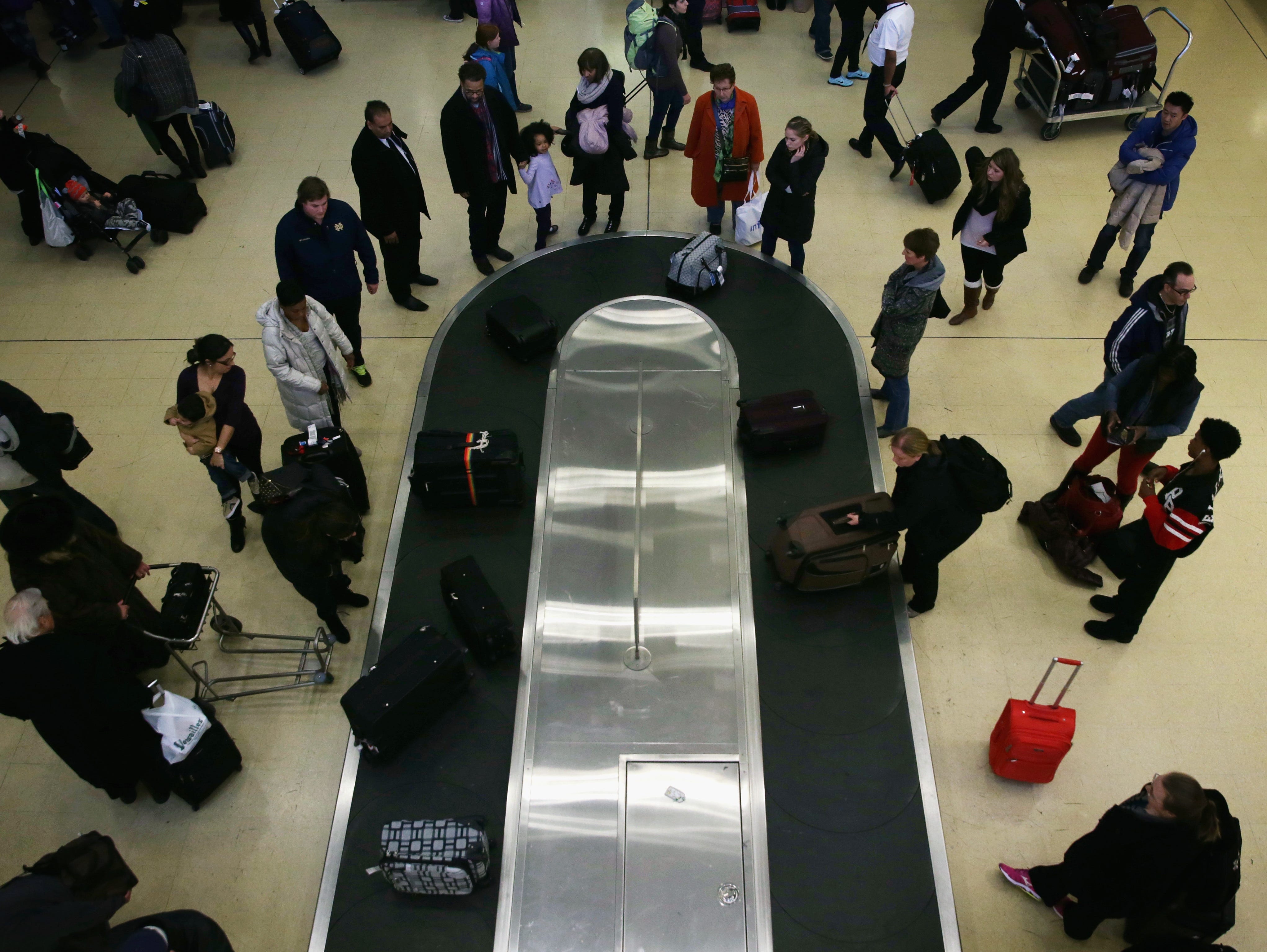 Travelers wait for their luggage after arriving at Washington Reagan National Airport on Nov. 26, 2014.