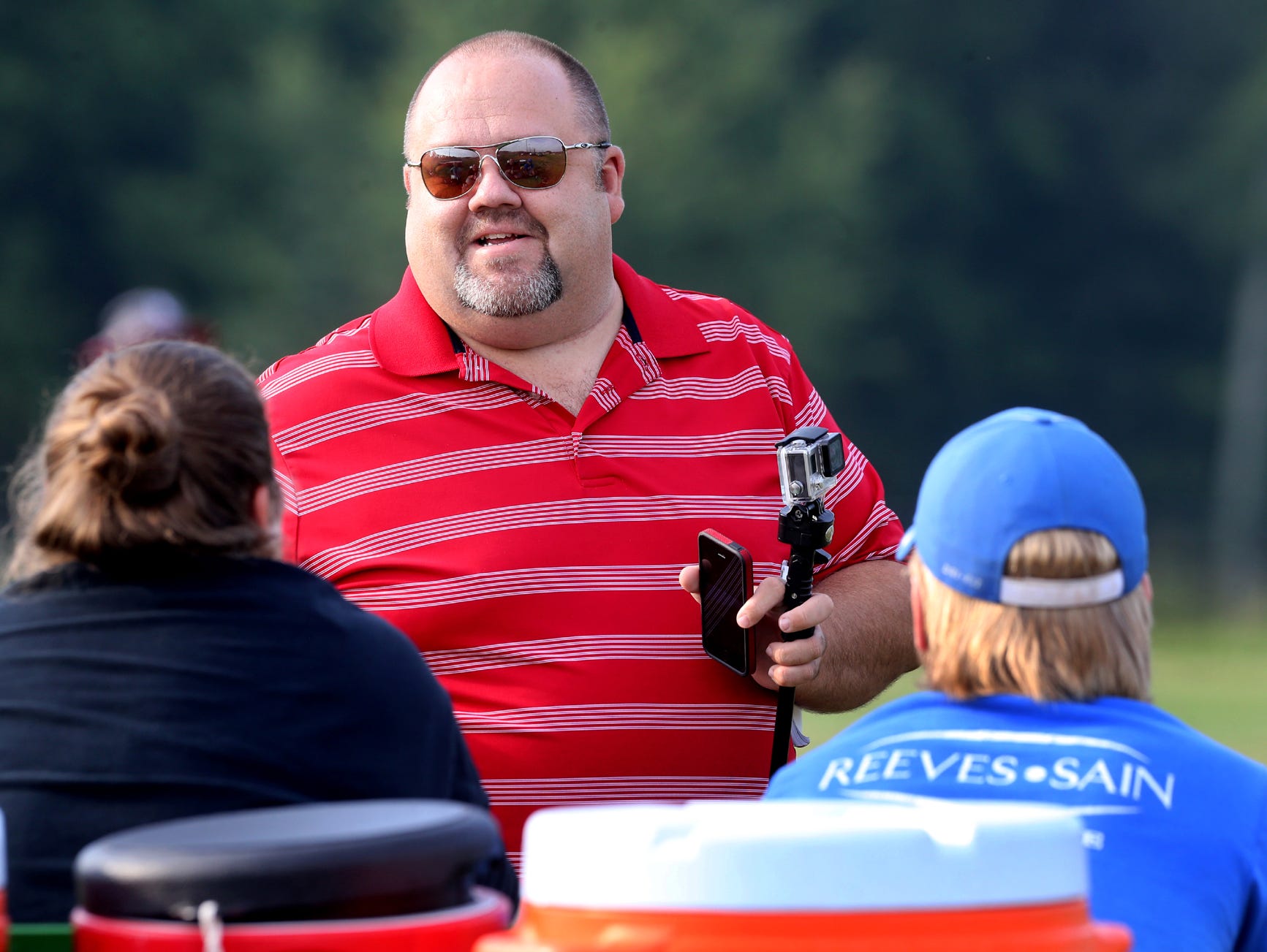 Tom Kreager, DNJ high school sports reporter, talks with some of the athletic trainers at Stewarts Creek with his iPhone and GoPro in hand, as Kreager arrives at Stewarts Creek for the school's first day of practice in full pads Monday, July 27, 2015.