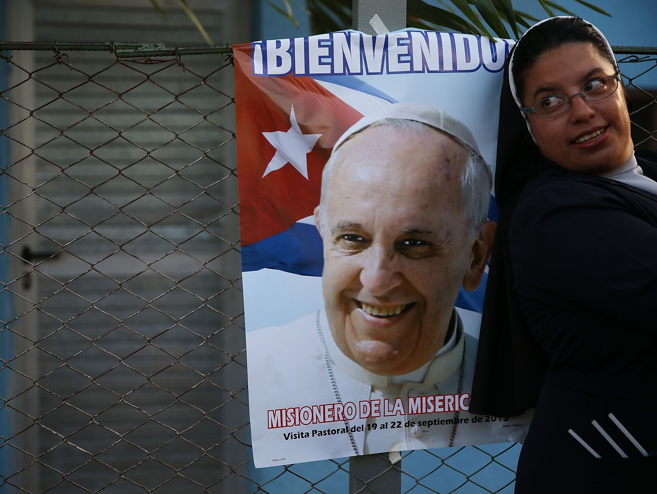 A nun is seen next to a poster of Pope Francis, who is scheduled to visit Holguin, Cuba.