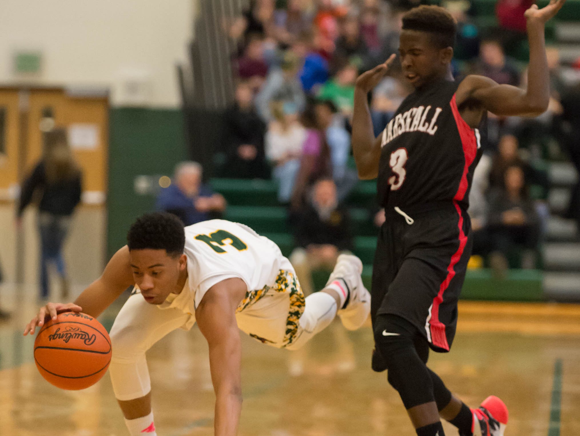 Pennfield's Ronald Jamierson (3) gets triped by Marshall's Marcus Walters (3) during Friday night's game.