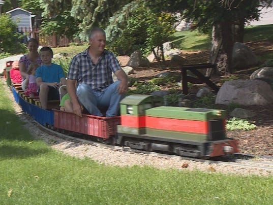 Enthusiast's ride-on model train circles his house