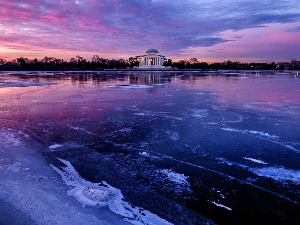 The Jefferson Memorial is reflected in the frozen surface of the Tidal Basin at daybreak in Washington. The Tidal Basin, famous for the Cherry Trees that surround it, is a sheet of ice after several days of bitter cold weather.