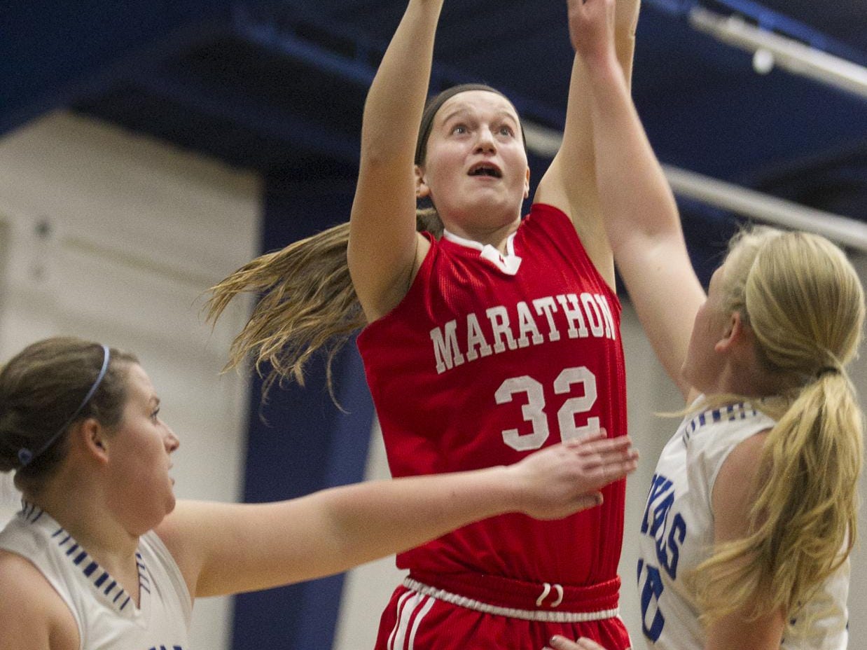 Marathon's Natasha Hanke, center, shoots over Assumption's Joelynn Frisch, left, and Macyn Krings, right, during the first half of the Marawood Conference girls basketball game at Assumption High School in Wisconsin Rapids, Tuesday, Dec. 1, 2015.