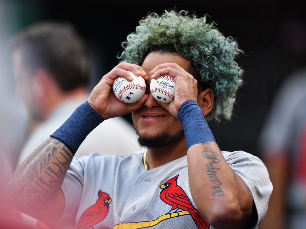 Carlos Martinez of the St. Louis Cardinals turns a pair of baseballs into binoculars in the dugout during the second inning against the Cincinnati Reds at Great American Ball Park in Cincinnati.