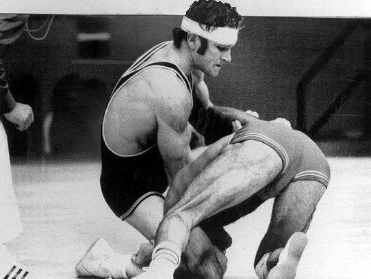 Dan Gable is showing dominating an opponent during