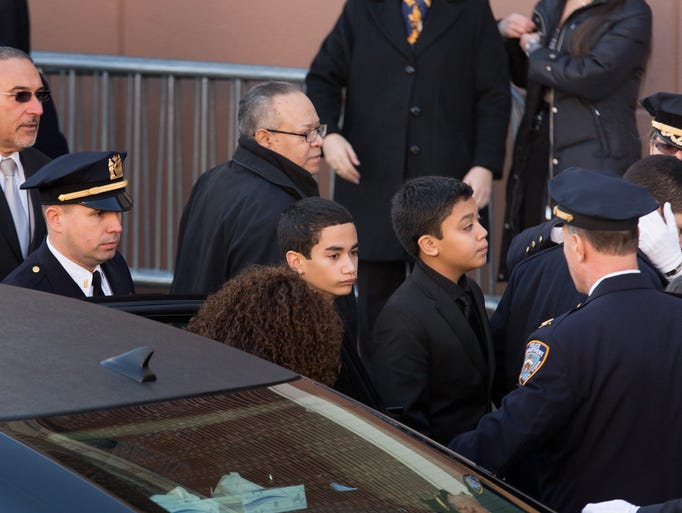 Jaden Ramos, center, arrives at the funeral for his