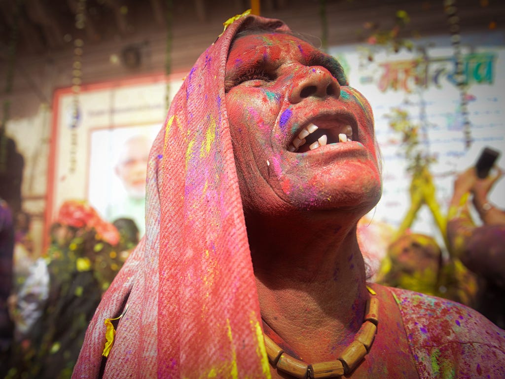 An Indian widow gestures covered in colored powder while dancing during Holi festival or festival of colors celebrations in Vrindavan. Holi, the popular Hindu spring festival is observed at the end of the winter season on the last full moon of the lu