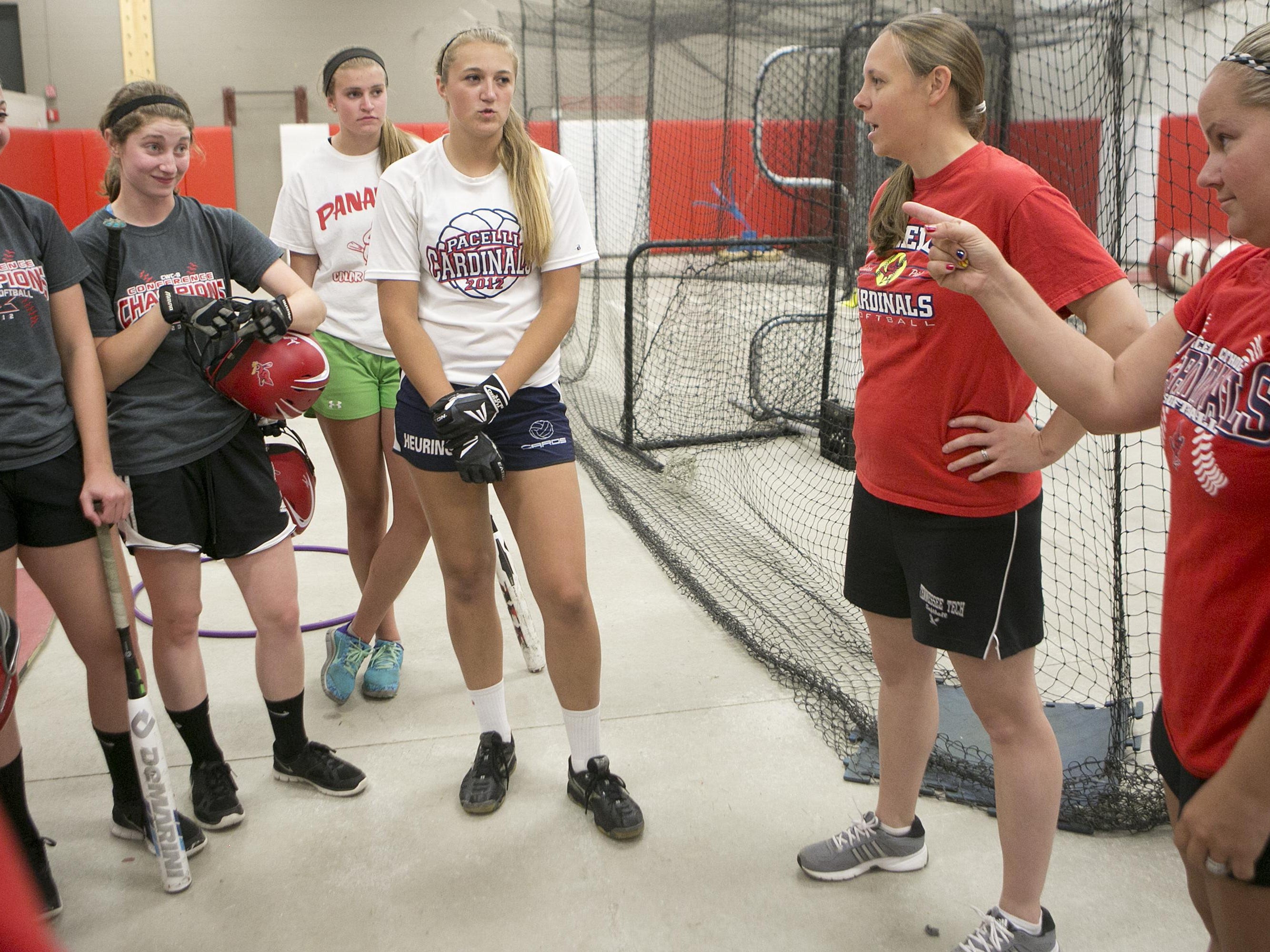 Pacelli's assistant softball coaches Beth Boden Nemec, center, and Stephanie Treichel, right, talk to the softball players during practice in the batting cages at Pacelli High School in Stevens Point, Friday, June 12, 2015.