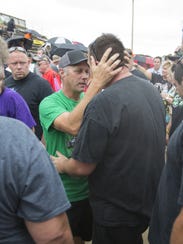 Tim Clauson (middle), embraces well-wishers at a tribute