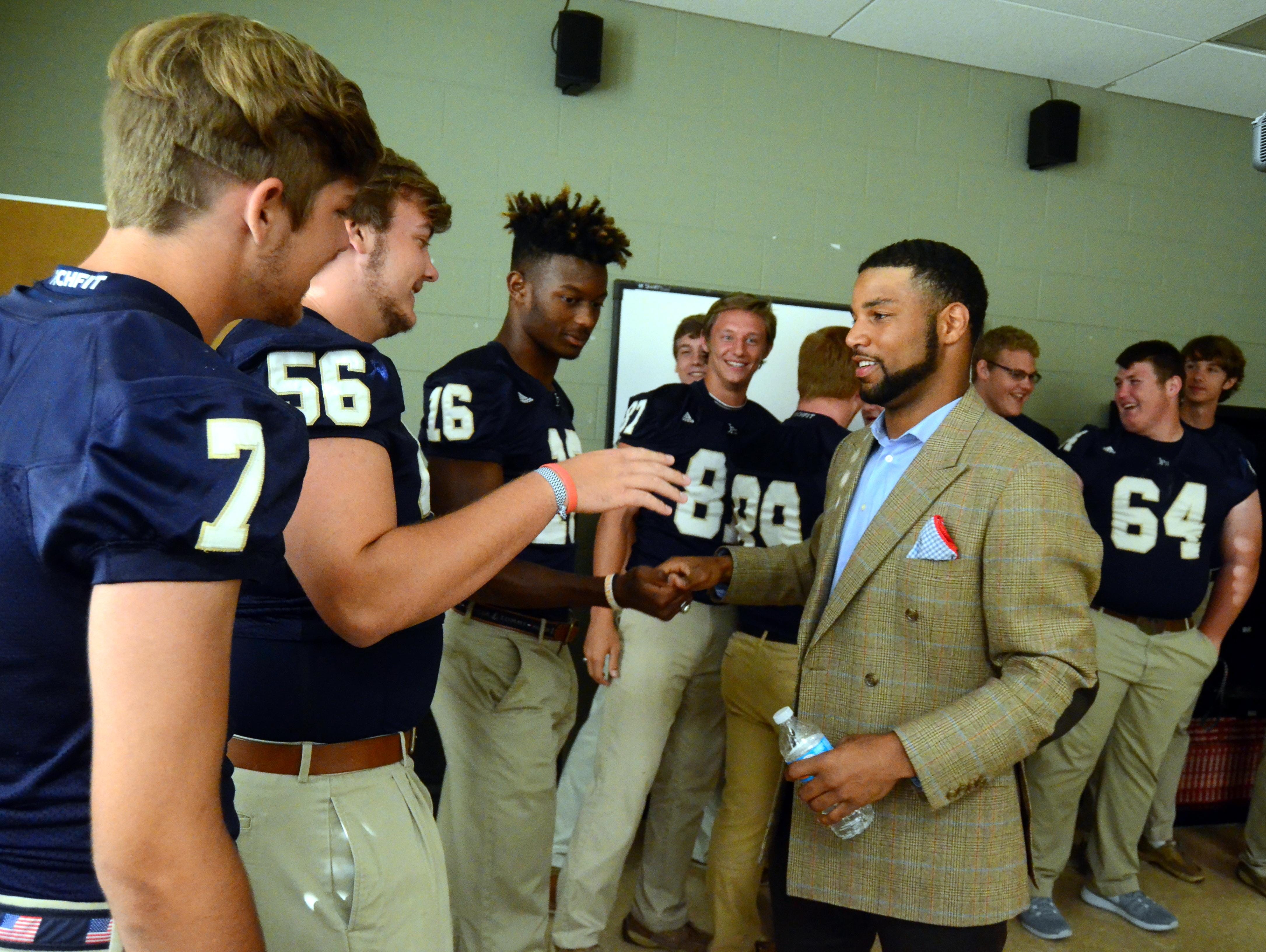 Detroit Lions wide receiver Golden Tate greets senior members of the Pope John Paul II High football team on Thursday evening, when the school retired his number.