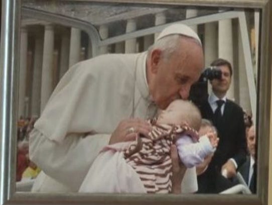 A portrait of Pope Francis kissing Ave hangs in the