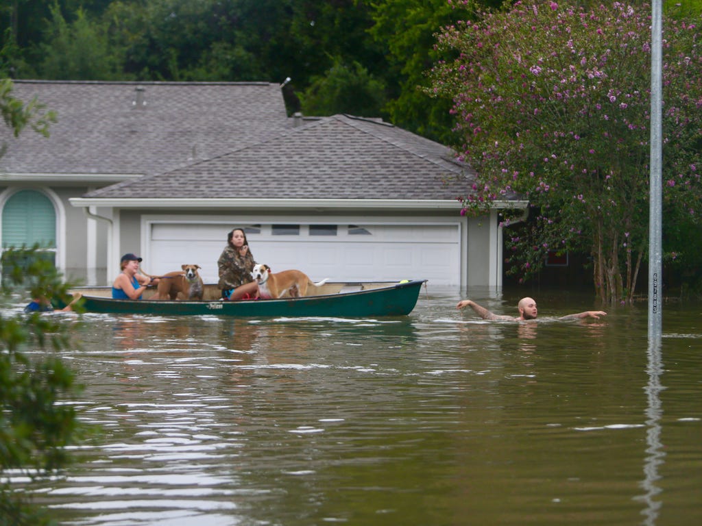 A family evacuates their home in Houston, Sunday, Aug. 27, 2017.  Rescuers answered hundreds of calls for help Sunday as floodwaters from the remnants of Hurricane Harvey rose high enough to begin filling second-story homes, and authorities urged str
