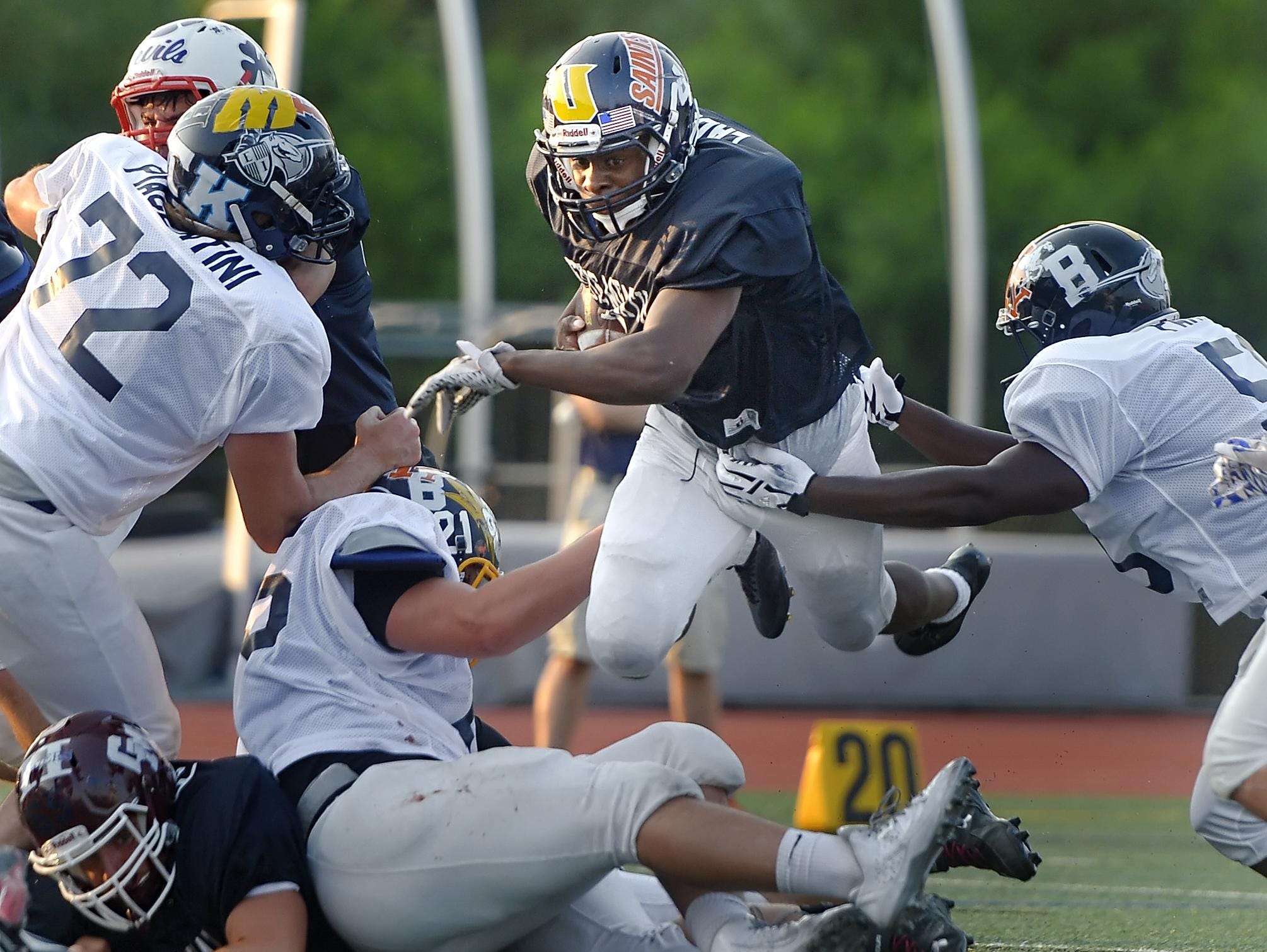 Spencerport's Xavier Eaddy, center, dives over the pile during the 33rd Annual Eddie Meath All-Star Game played at Eastridge High School on July 11, 2015.