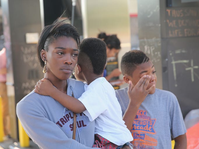 FERGUSON, MO - AUGUST 15: People gather in the lot of the Quick Trip gas station, which was burned during rioting, as Ferguson Police Chief Thomas Jackson releases the name of the Ferguson police officer responsible for the August 9, shooting death of teenager Michael Brown on August 15, 2014 in Ferguson, Missouri.