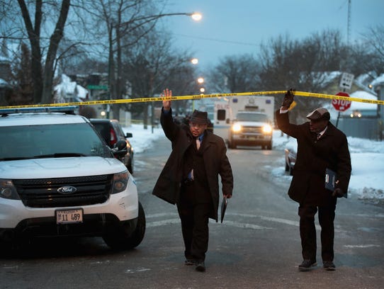 Police investigate the scene of a quadruple homicide