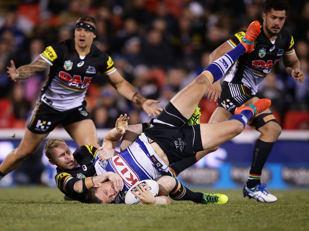 Kerrod Holland of the Bulldogs is tackled by Peter Wallace of the Panthers during the round 21 NRL match between the Penrith Panthers and the Canterbury Bulldogs at Pepper Stadium in Sydney, Australia.
