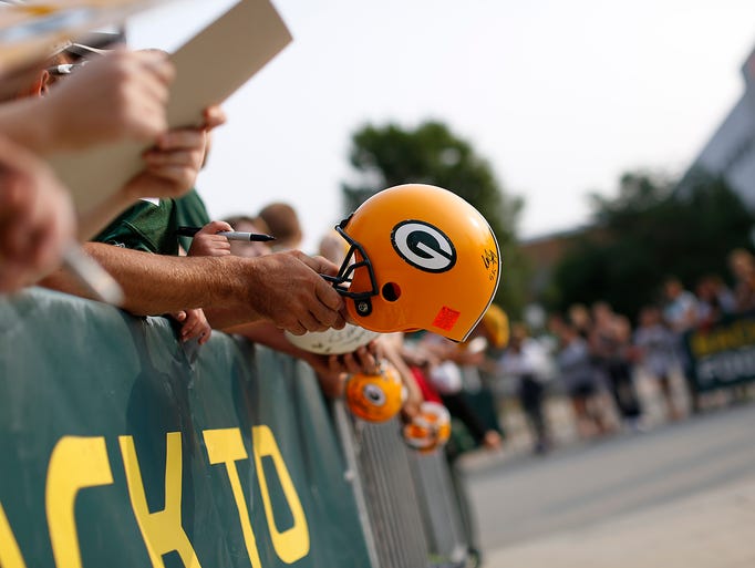 Fans hold out items to be autographed by Green Bay Packers players during training camp practice at Ray Nitschke Field on Friday, Aug. 1, 2014. Evan Siegle/Press-Gazette Media