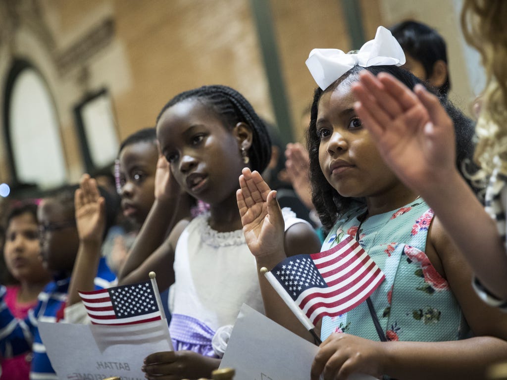 Children take the Oath of Allegiance as they become U.S. citizens during a citizenship ceremony at The Bronx Zoo. Thirty-two children, ranging in age from 5 to 13 years old, attended the ceremony.