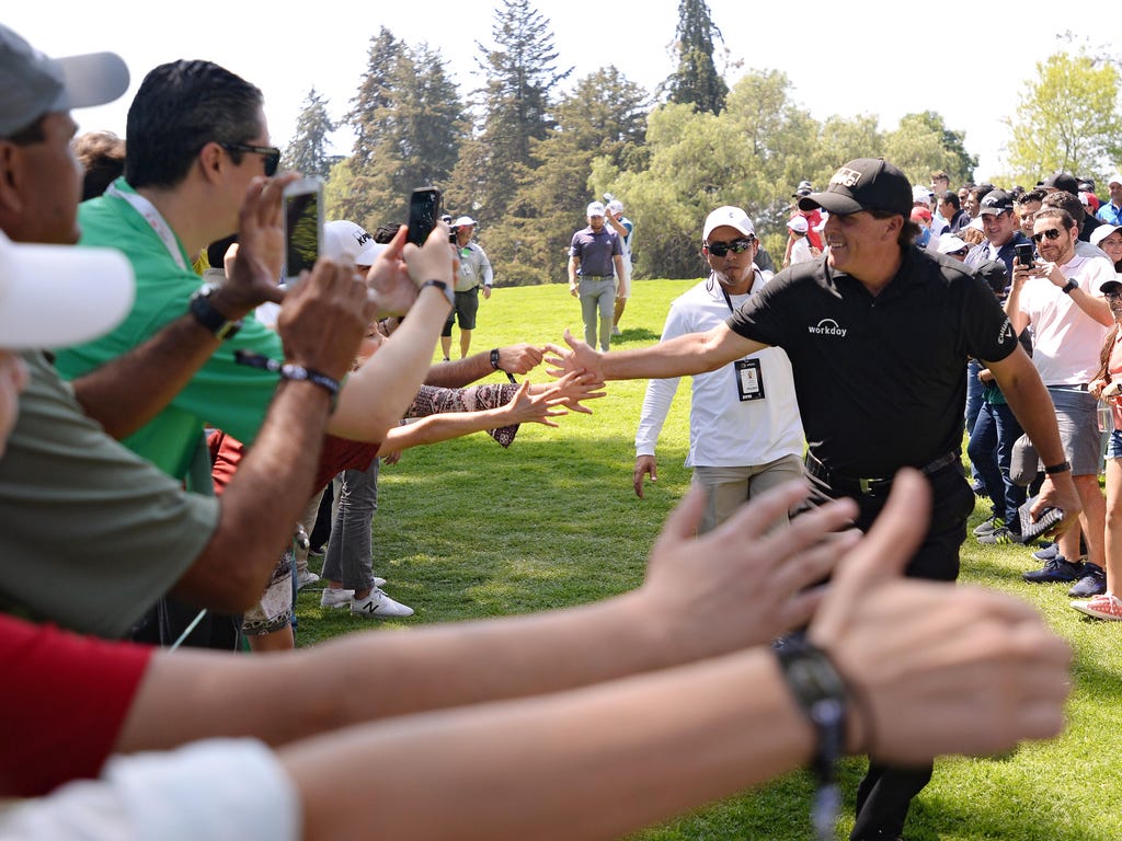 Phil Mickelson slaps hands with fans as he heads to the sixth tee during the final round of the WGC - Mexico Championship golf tournament at Club de Golf Chapultepec in Mexico City.
